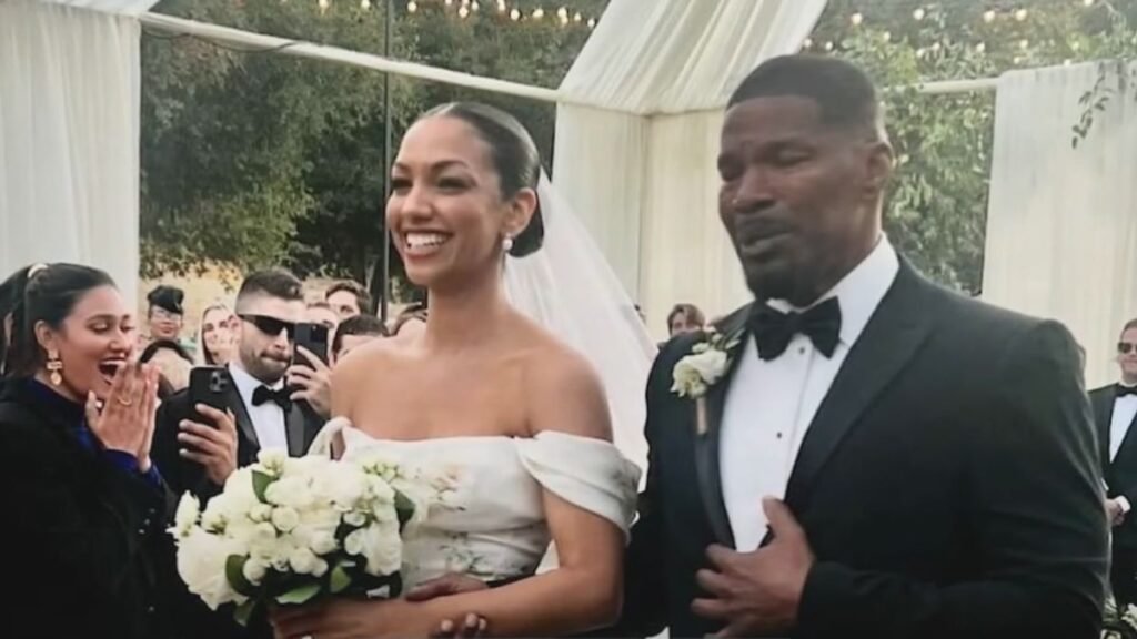 Corinne Foxx and Jamie Foxx waling down the aisle 