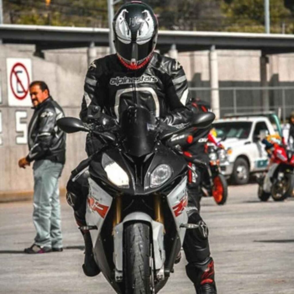 A rider sitting on motorbike wearing leather jacket 