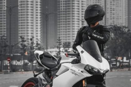 A rider wearing black leather jacket standing next to Yamaha R1