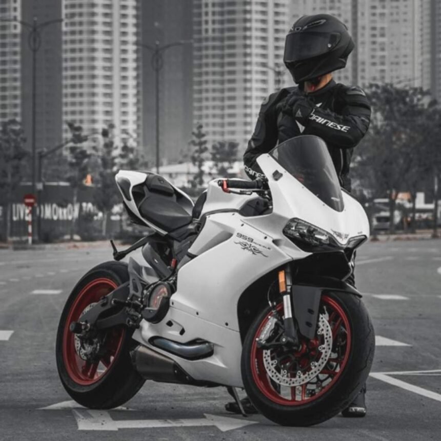 A rider wearing black leather jacket standing next to Yamaha R1